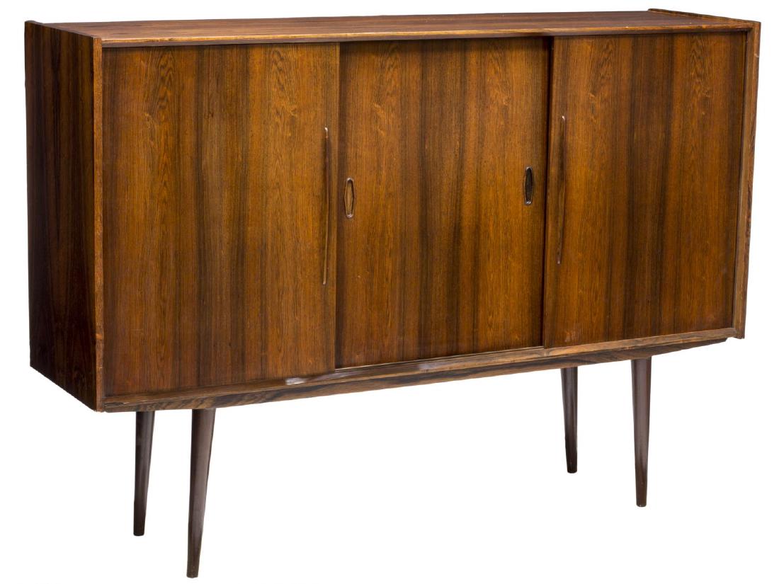 DANISH MID-CENTURY MODERN ROSEWOOD SIDEBOARD: Danish mid-century modern rosewood sideboard, c. 1950's, the rectangular case fitted with three sliding doors, concealing shelving and drawers, rising on cylindrical tapered legs, approx 45"h, 63"w, 1