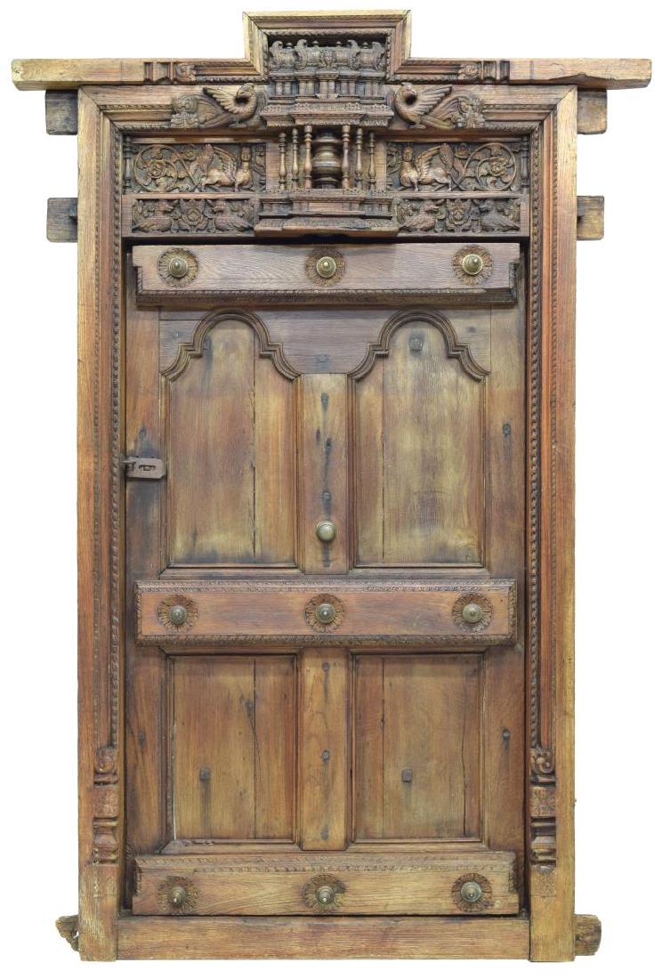 ARCHITECTURAL HIGHLY CARVED FRENCH COLONIAL DOOR: French colonial door, 18th c., with highly carved frieze depicting Lamassu (winged bulls), birds, architectural elements, and scrolling foliage, over single four-paneled door, with metal fittings, ove