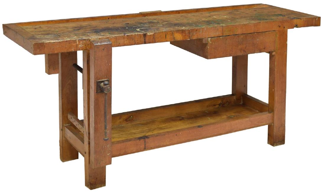 INDUSTRIAL CRAFTSMAN'S WOOD WORK BENCH TABLE: Craftsman's work bench table, Continental, 20th c., having rectangular top, with recessed trough, drawer and single crank vice, rising on block legs, joined by a lower tier, approx 30.25"h, 66.75"w, 2