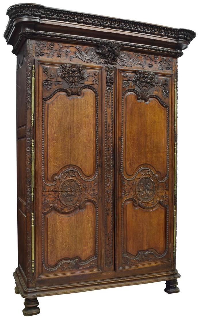 FRENCH LOUIS XV STYLE CARVED MARRIAGE ARMOIRE: French Louis XV style oak marriage armoire, late 19th c., the foliate carved stepped cornice with love birds in a floral basket over two paneled doors with detailed foliate carving, large polished bra