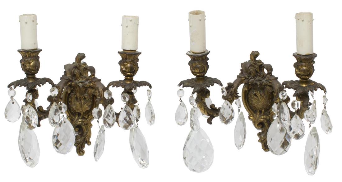 2) ITALIAN GILT-METAL TWO-LIGHT PRISM WALL SCONCES: (lot of 2) Italian gilt metal two-light wall sconces in the French taste, rocaille and acanthus decor on two branches hung with faceted prisms of varied size, in need of wiring, approx 11"h, 9"w, 7", 