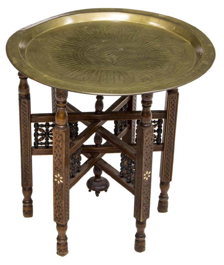 ARABESQUE SYRIAN BRASS & WOOD TRAY TOP TABLE: Syrian brass tray top table, the patinated and patterned tray, on an arabesque carved wood base, with inlaid bone accents, approx 21"h, 21"diam (to tray top) Start Price $50.00