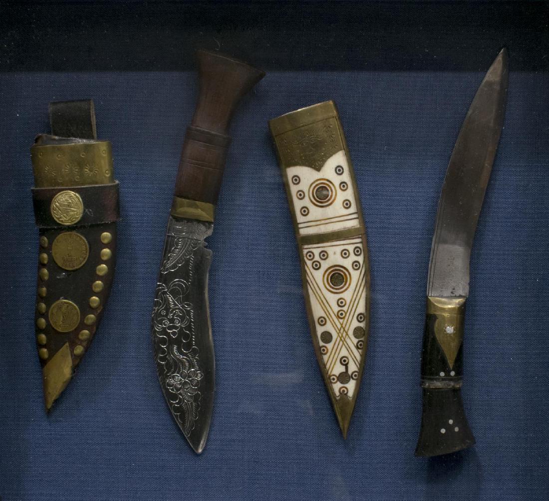 (2) SHADOW BOXED NEPAL KNIVES, COINS, SHEATHS: Shadow box framed vintage Nepal knives and sheath, (1) one blade with foliate and scrolled engraving, the sheath in leather and brass with affixed Nepal coins; (1) the other sheath with decoration inl