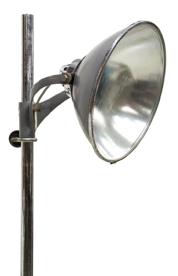WILMOT CASTLE CO. INDUSTRIAL MEDICAL SPOT LIGHT: Industrial medical light, mid 20th c., by Wilmot Castle Co., chromed steel standard with adjustable spot light, over tripod base on casters, some pitting and patination to metal, approx 61.75"h, 22"di