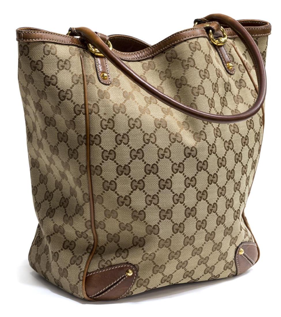 GUCCI BEIGE MONOGRAM CANVAS & LEATHER TOTE BAG: Gucci beige monogram canvas shoulder tote, having brown leather handles, piping and trim, lined interior with single zip and cell pockets, set on small gilt metal feet, retaining dust bag, slight wear