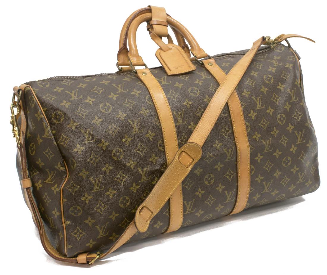 LOUIS VUITTON MONOGRAM KEEPALL BANDOULIERE DUFFLE: Louis Vuitton monogram canvas "KeepAll Bandouliere" duffle bag, leather shoulder strap, handles, trim and piping, zipper top opening to brown interior, retaining lock (no keys), luggage tag and handle