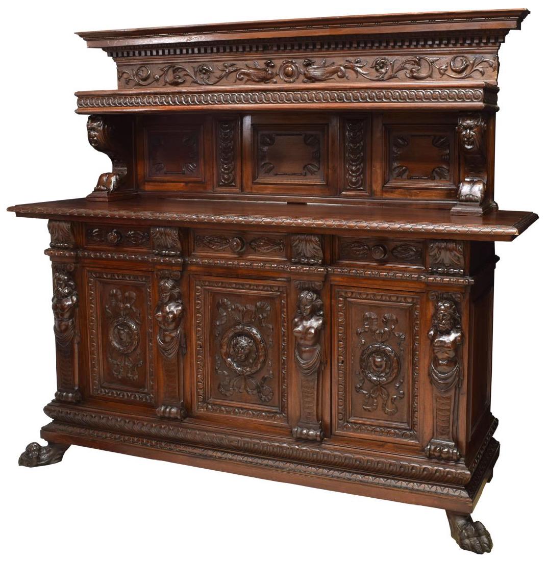 ITALIAN RENAISSANCE REVIVAL FIGURAL SIDEBOARD: Italian Renaissance Revival heavily carved sideboard, early 20th c., the corniced top over mask and foliate frieze and shelved back, scrolled mask supports above the rectangular case fitted with three