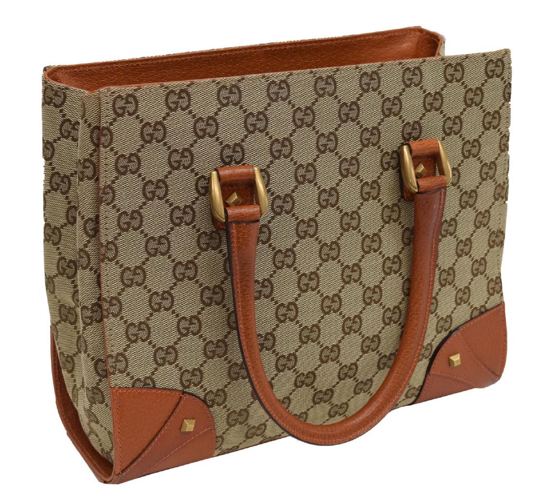 GUCCI BROWN & TAN GG CANVAS TOTE BAG WITH STUDS: Gucci tote bag, in brown and tan GG canvas, with gold-tone hardware, brown leather trim, dual rolled shoulder straps, stud embellishments, black woven lining, zipper and cell phone pockets at interior