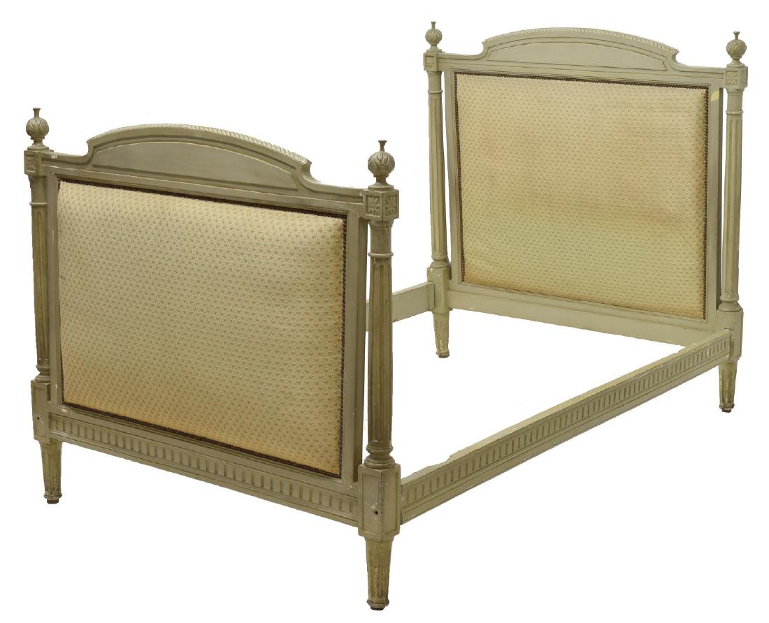 FRENCH PAINTED WOOD CARVED BED, EARLY 20TH C.: French painted wood bed, early 20th c., having foliate carved head and footboard, with thistle finials, over fluted column supports, having beige, green, and pink floral pattern upholstery, with nail 