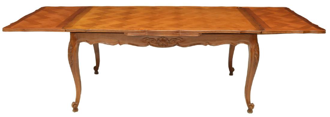FRENCH PROVINCIAL PARQUETRY DRAW LEAF DINING TABLE: French Provincial draw leaf dining table, 20th c., having parquetry top, over shaped skirt, rising on carved cabriole legs, ending in scroll feet, some marks to top, approx 29"h, 62.25"w, 39.25"d (clo