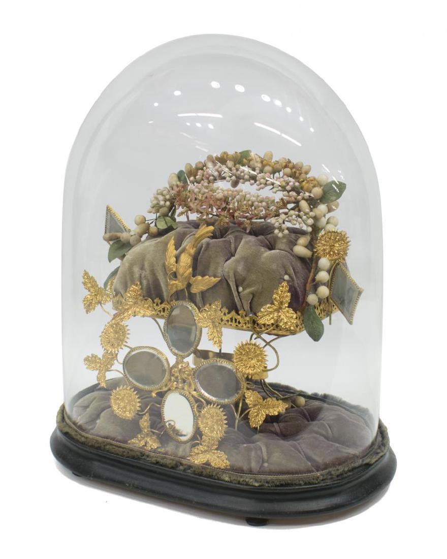 ANTIQUE CONTINENTAL CLOCHE & WEDDING CROWN: Continental glass dome, 19th c., the oval shaped dome fitted on a wood base, enclosing gilt metal stand with songbird, climbing flowers and beveled mirrors, the stand holding a wedding crown of faux f
