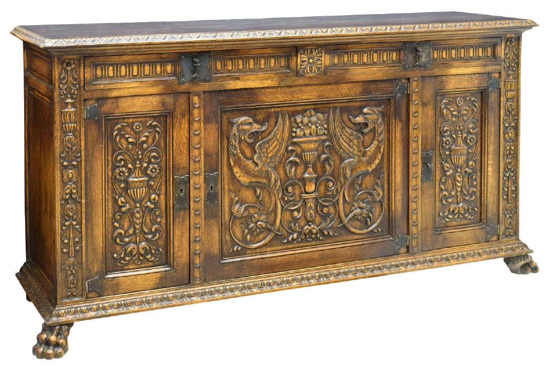 SPANISH RENAISSANCE REVIVAL STYLE OAK SIDEBOARD: Spanish Renaissance revival style heavily carved oak sideboard, 19th c., rectangular top, acanthus molding, over two drawers with metal cross pulls, above three door cabinet, vasiform, foliate, and gr