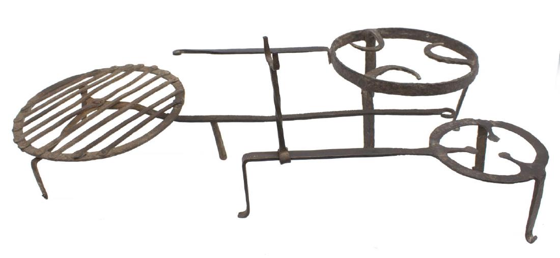 (3) 18TH / 19TH C. FORGED IRON TRIVETS & BROILER: (lot of 3) American hand forged iron cooking implements, 18th / 19th c., including: (1) whirling broiler, with elongated stem, ending in hook, 32"l, 12.5"w; (2) footed trivets, the smaller with moveab