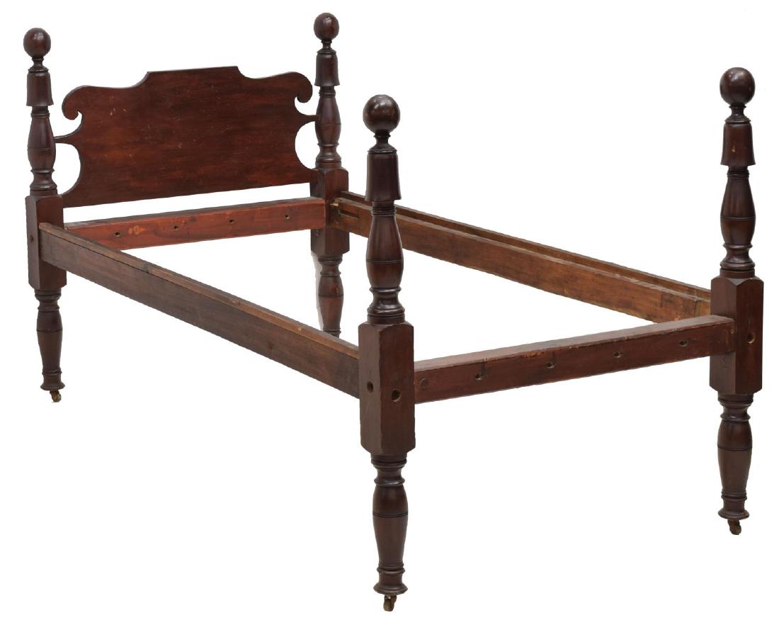 AMERICAN PRIMITIVE MAHOGANY CANNONBALL ROPE BED: American primitive cannonball rope bed, 19th c., carved mahogany frame, shaped head and footboards, with cannonball finials, over turned supports, rising on block-and-vase turned legs, caster feet, ex