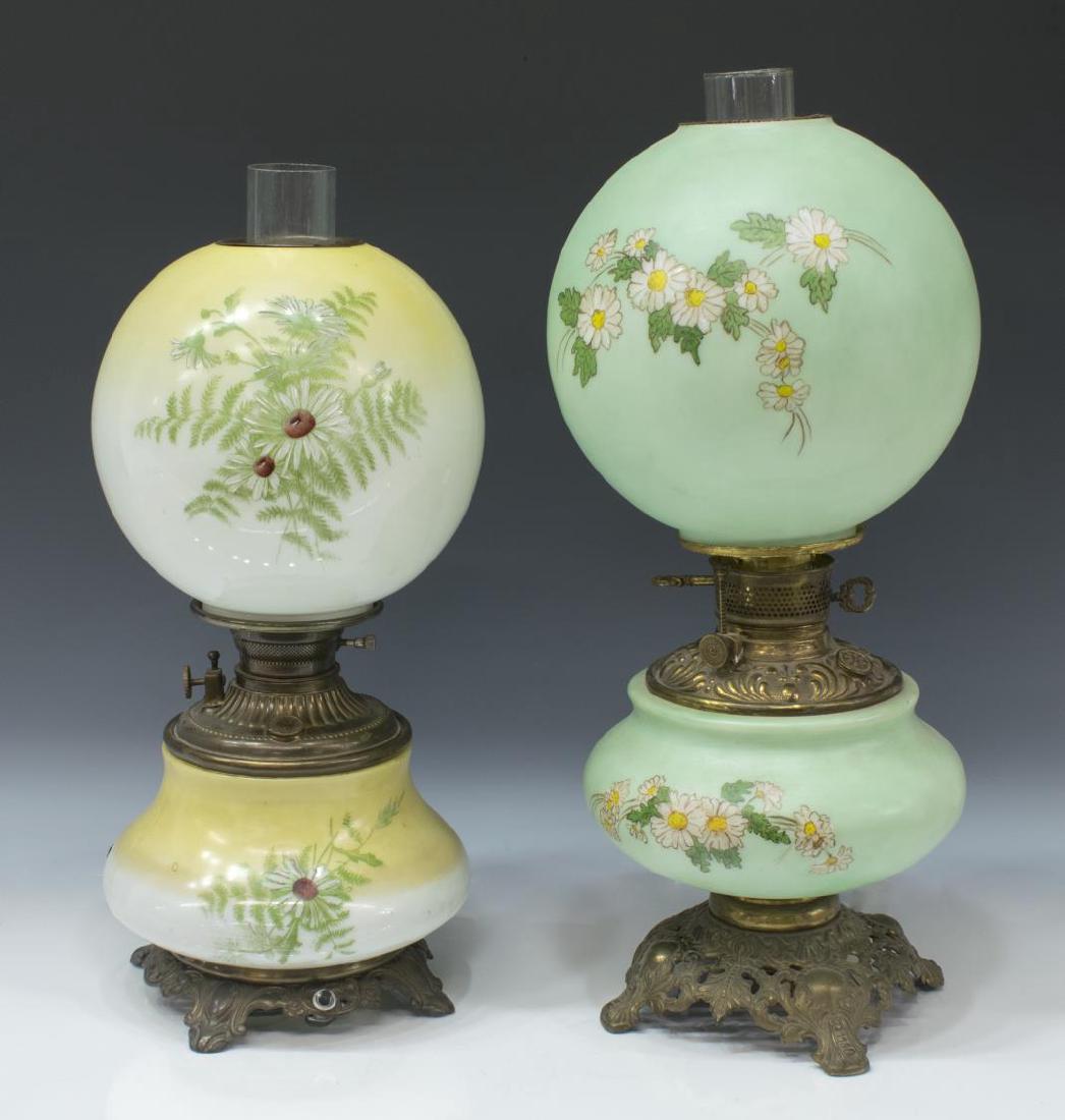 (2) AMERICAN 'GONE W/ THE WIND' BANQUET OIL LAMPS: (lot of 2) "Gone with the Wind" converted oil lamps, American, c. 1900, including: (1) Moses, Swann & McLewee Co. lamp, gilt metal rocaille base, frosted glass shades with painted floral and foliate m