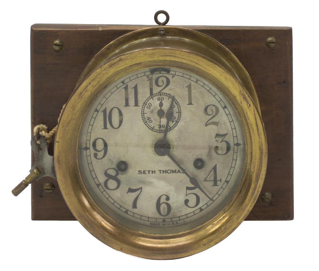 SETH THOMAS BRASS SHIPS BELLS CLOCK: Ships bell clock, in brass housing, hinged front, Arabic numerals, with seconds dial to top, with time and strike movements, strikes ships on the half hour, separate strike lever, mounted on wooden bo