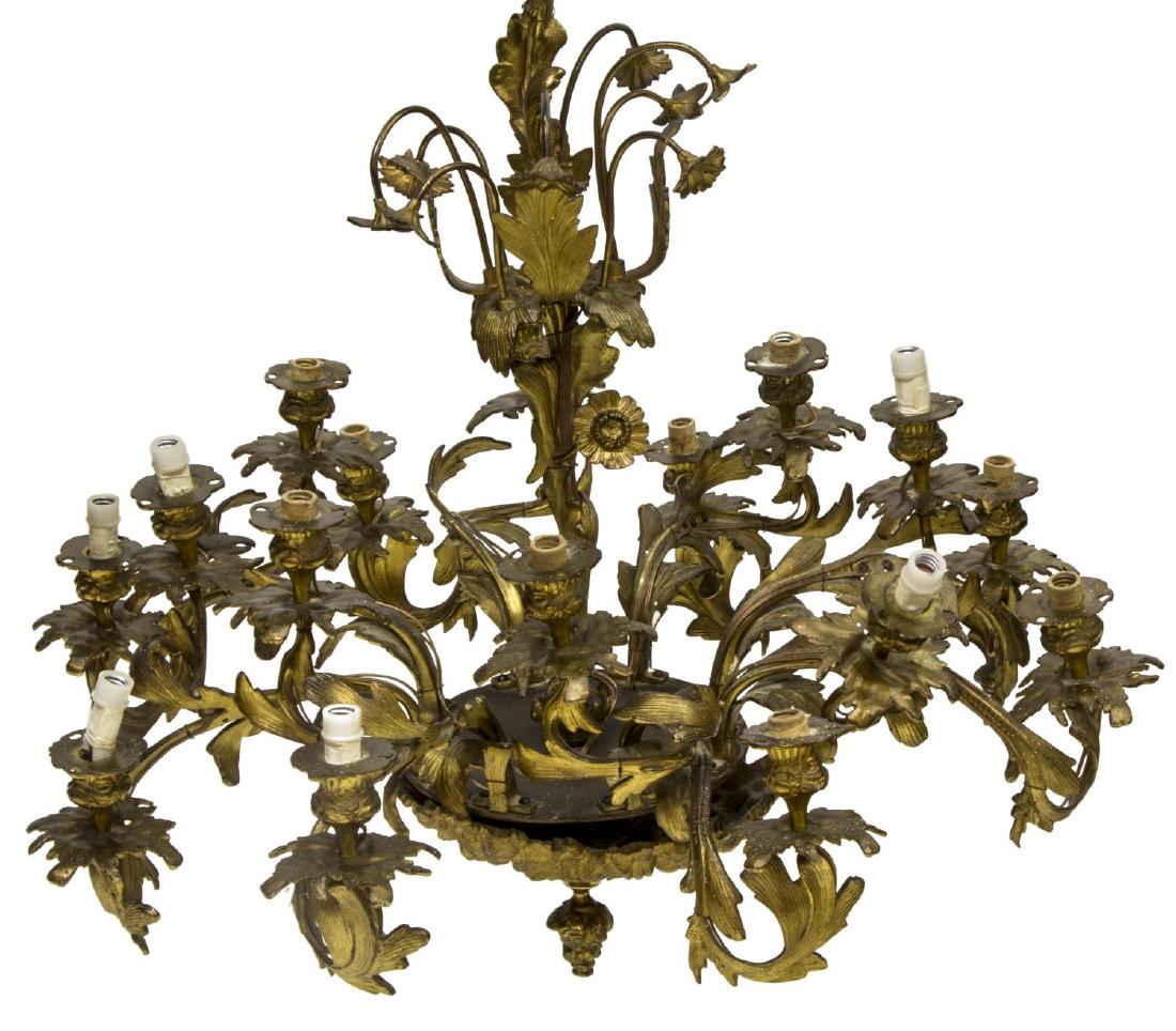SPANISH GILT BRONZE FOLIATE 16 LIGHT CHANDLIER: Gilt bronze 16 light chandelier, Northern Spain, foliate and floriform standard, circular base, issuing eight foliate arms, ending in two bobeches and fixtures, acorn drop finial to underside of base,