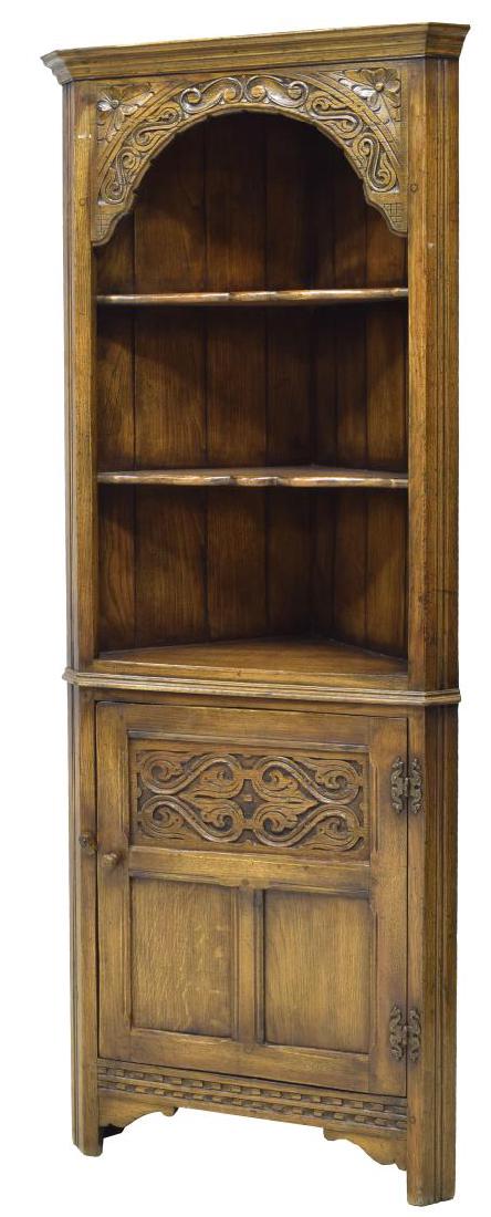 TITCHMARSH & GOODWIN OAK CORNER CABINET: English oak corner cabinet by Titchmarsh & Goodwin, Suffolk, c. 1970, a stepped cornice over an arched foliate carved panel, two scalloped edge shelves, a lower paneled and carved door, rising on bloc