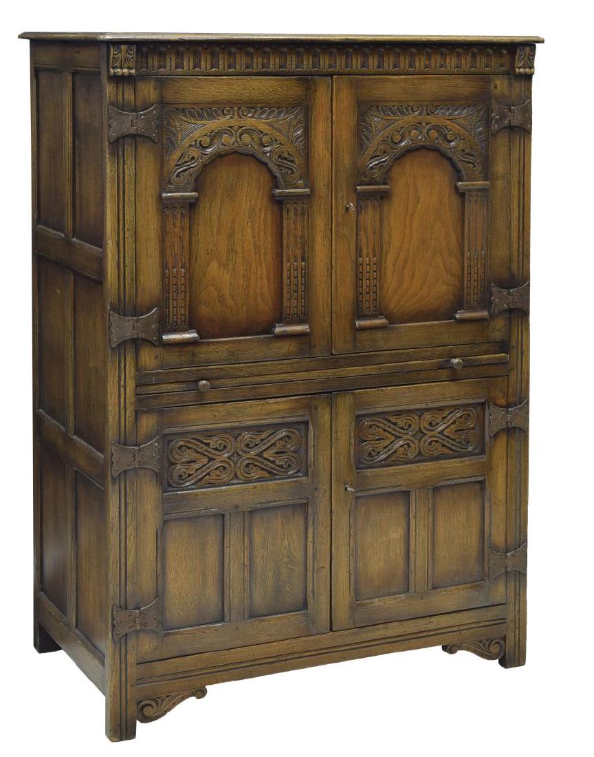 ENGLISH CARVED OAK DRINKS CABINET: English Titchmarsh & Goodwin oak drinks cabinet, two carved front doors over a pull out tray above two doors, risingf on block feet, 52"h, 36.5"w, 21"d Start Price: 250.00