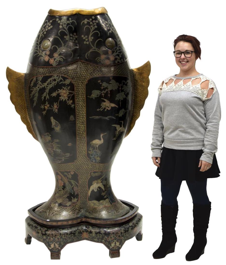 LARGE BLACK LACQUER DOUBLE FISH ABUNDANCE VASE: Large black lacquer parcel gilt abundance vase, with shaped double fish body, incised with polychrome geometric, foliate, and bird designs, on shaped lacquer base, with Greek key edges, over foliate a