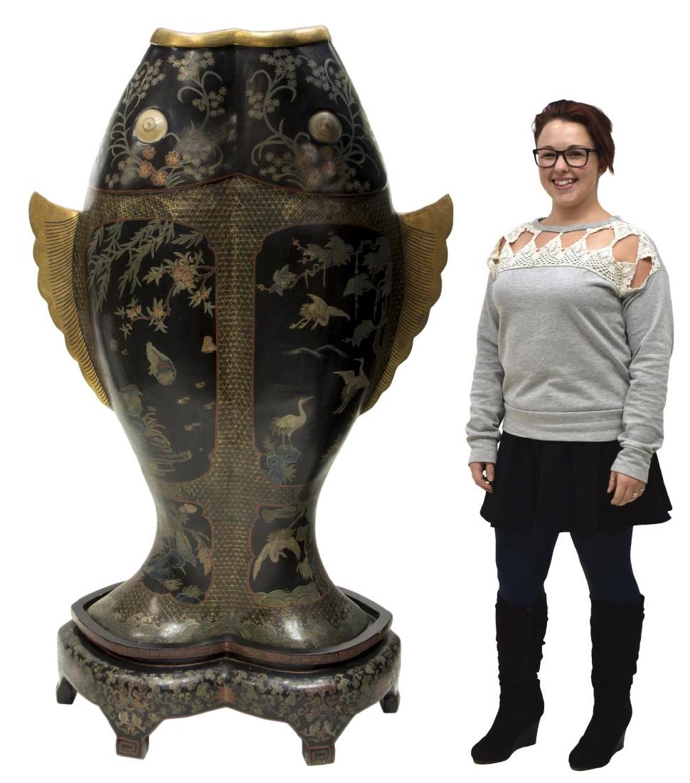 LARGE BLACK LACQUER DOUBLE FISH ABUNDANCE VASE: Large black lacquer parcel gilt abundance vase, with shaped double fish body, incised with polychrome geometric, foliate, and bird designs, on shaped lacquer base, with Greek key edges, over foliate a