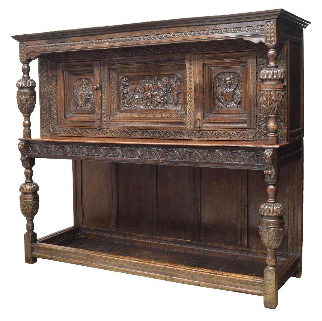 ENGLISH HEAVILY CARVED OAK COURT SIDEBOARD: English heavily carved oak court cupboard, c. 1800, having corniced top, over two cabinets, with carved figural reserves (one being Queen Elizabeth I), doors separated by carved figural scene, having 