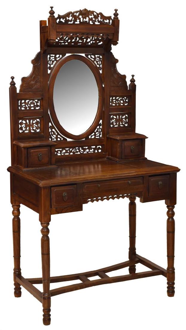 CHINESE STYLE CARVED HARDWOOD VANITY TABLE: Chinese style carved hardwood vanity table, having pierced and carved foliate crest and mirror frame, with turned urn finials, holding pivoting oval flat plate mirror, two small side drawers with bras