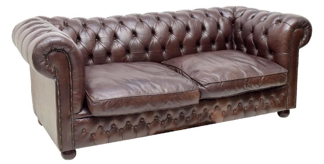 CHESTERFIELD BROWN LEATHER TWO-SEAT SOFA: Chesterfield brown leather two-seat sofa, having button back and arms, with two removable seat cushions, rising on turned wood bun feet, approx 30.5"h, 76"w, 36.25"d Start Price: 500.00