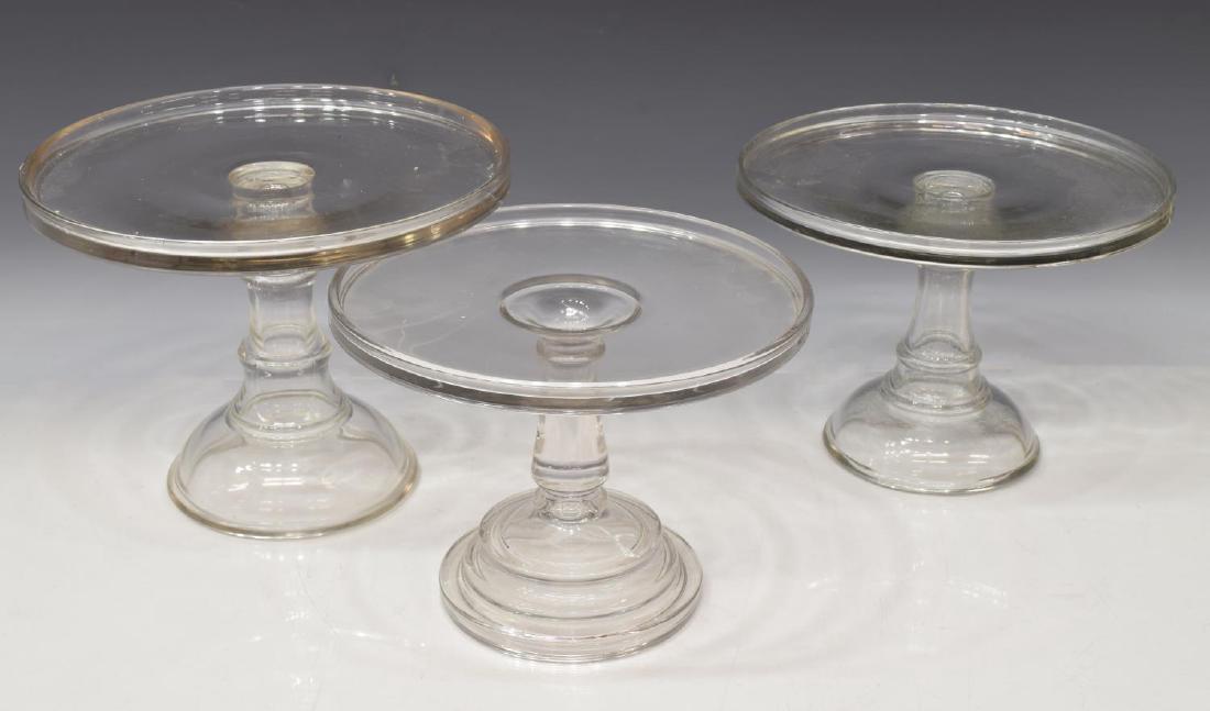 (3) COLORLESS MOLDED GLASS CAKE STANDS: (lot of 3) Colorless molded glass cake stands, having gallery rims, various patterns and sizes, largest: 8"h, 10.25"diam; 8lbs total Start Price: $50.00