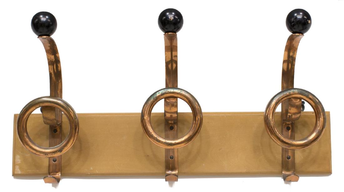 ITALIAN MID-CENTURY MODERN WALL-MOUNTED COAT RACK: Italian mid-century modern wall mounted coat rack, mid 20th c., rectangular blonde wood backboard, mounted with three copper-tone hooks, each topped with black wooden finial, some loss to copper finis