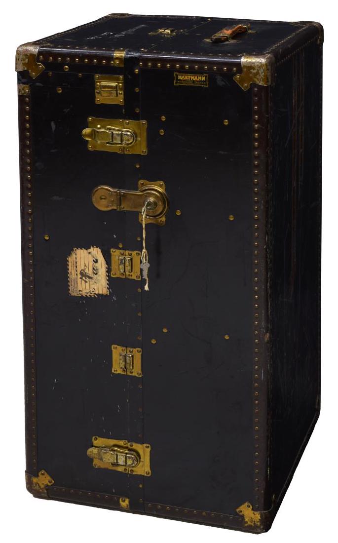 HARTMANN LUGGAGE WARDROBE STEAMER TRUNK: Wardrobe steamer trunk by Hartmann Luggage, early 20th c., metal banded with leather handles and gilt brass hardware, interior fitted with four drawers to one side and hanging rods to the other, accom