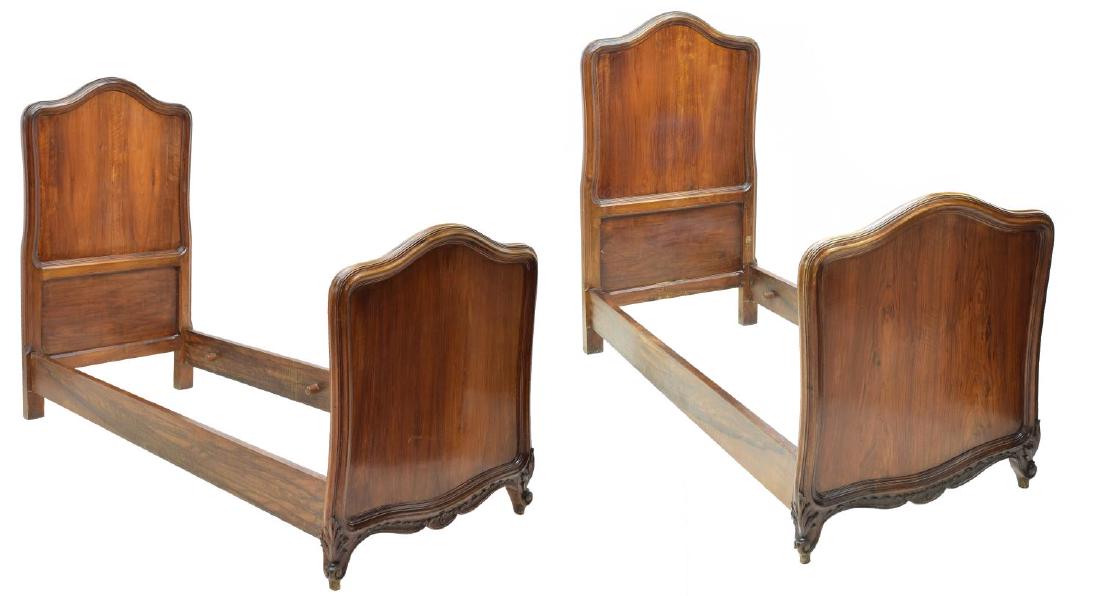 (2) ITALIAN LOUIS XV STYLE WALNUT BEDS, 19TH C.: (pair) Italian Louis XV style carved walnut beds, 19th c., the head and footboards having bowed tops, rising on acanthus accented scroll feet, exterior: approx 61"h, 34.25"w, 82.25"d; interior: approx