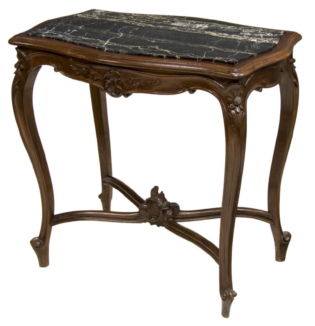 ITALIAN ROCOCO WALNUT MARBLE TOP PARLOR TABLE: Italian Rococo walnut parlor table, 19th c., the shaped top holding a black marble insert above the shell and floriform carved frieze, rising on stretcher-joined trifid foot cabriole legs, approx 30.7