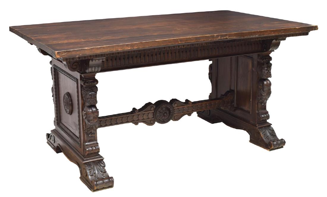 ITALIAN RENAISSANCE REVIVAL MAHOGANY LIBRARY TABLE: Italian Renaissance Revival library table, early 20th c., in mahogany finish, having a heavily carved and molded frieze, rising on stretcher-joined figural carved trestle legs on scrolled feet, approx