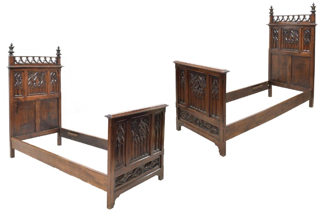 (2) ITALIAN GOTHIC REVIVAL MAHOGANY FINISH BEDS: (pair) Italian Gothic Revival mahogany finish beds, the headboard having foliate carved finials and pierced arcading to top, the head and footboard having carved foliate and arch design reserves, risi