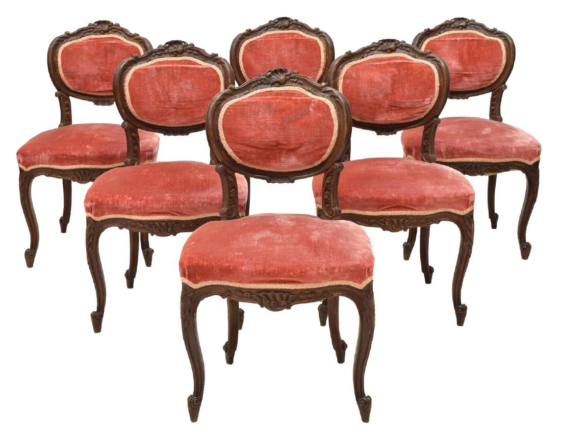 (6) ITALIAN ROCOCO STYLE WALNUT SIDE CHAIRS: (lot of 6) Italian Rococo style walnut side chairs, 19th c., with red velvet upholstery, a foliate and scroll carved crest rail over the oval shaped back, rising on scroll foot cabriole legs, approx 3