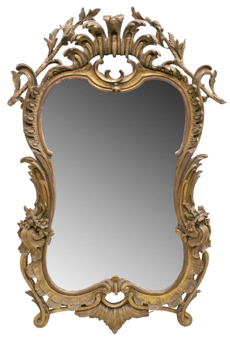 FRENCH ROCOCO REVIVAL GILT CARVED BEVELED MIRROR: French Rococo revival wall mirror, late 19th/ early 20th c., having pierced and carved gilt frame, with scrolling foliates, gadrooning, and floral sprays, all centering the shaped and beveled mirror p