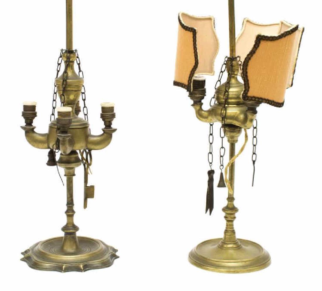 (2) CONTINENTAL BRASS ELECTRIFIED WHALE OIL LAMPS: (lot of 2) Continental brass electrified whale oil lamps, 19th c., each with handle holder ring at top: (1) having orange fabric shades over three lights, separated by three accessories hung on chains