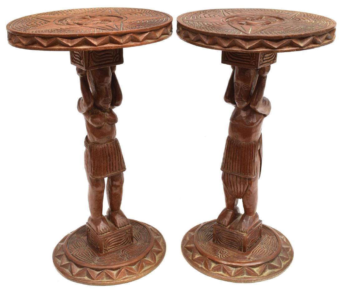 (2) AFRICAN CARVED WOOD FIGURAL PEDESTALS: (pair) African carved wood pedestals, both having round tops with a carved star around central figural reserve, standards carved as a woman and man, round carved bases, approx 19.75"h, 11.75"diam, 13.