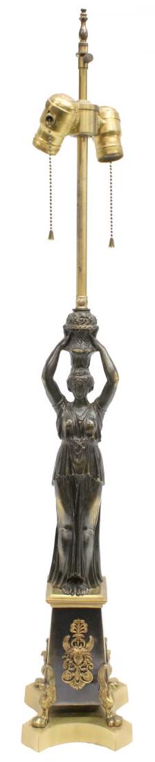 EMPIRE STYLE FIGURAL TWO-LIGHT TABLE LAMP: Empire style two-light table lamp, cast metal figure of a woman in diaphanous gown, holding basket of flowers above her head, standing on tapered pedestal with eagle brackets, over shaped base, approx