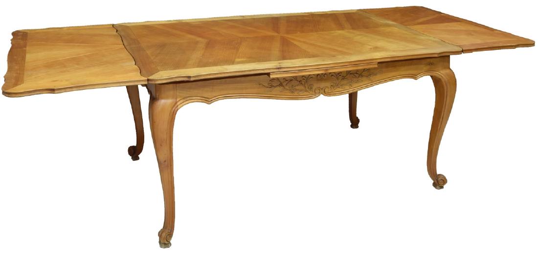 FRENCH PROVINCIAL DRAW LEAF DINING TABLE: French provincial carved draw leaf extension dining table, the shaped top with two pull out leaves to either end, rising on scroll foot cabriole legs, without leaves: approx 29.5"h, 58.5"w, 35"d; with