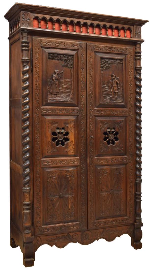 FRENCH BRITTANY FIGURAL CARVED OAK ARMOIRE: French Brittany carved oak armoire, 19th c., the corniced top over an arcaded frieze, carved twist accents flanking a two-door cabinet with figural reserves and pierced medallions, interior fitted wit