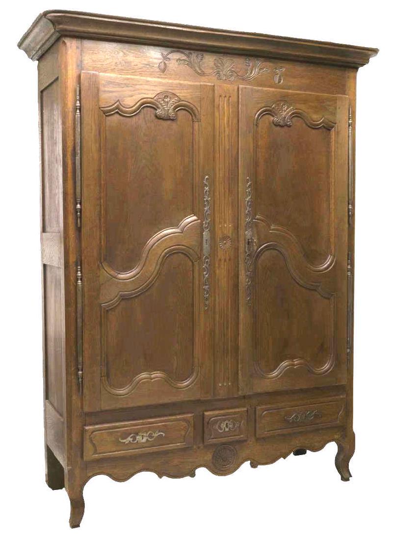 LOUIS XV STYLE FLORAL & FOLIATE CARVED OAK ARMOIRE: Louis XV style oak armoire, 19th c., the overhang cornice, above foliate carved frieze and two paneled doors carved with flowers and hung on long hinges, three drawers below, rise on front cabriole le