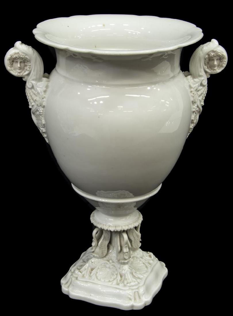 LARGE FRENCH NEOCLASSICAL STYLE PORCELAIN VASE: French Neoclassical style white porcelain vase, having a flared rim, figural mask and shell handles, rising on four swans and foliated base, unmarked, residue to interior, approx 15.5"h, 12.5"w, 7.75l