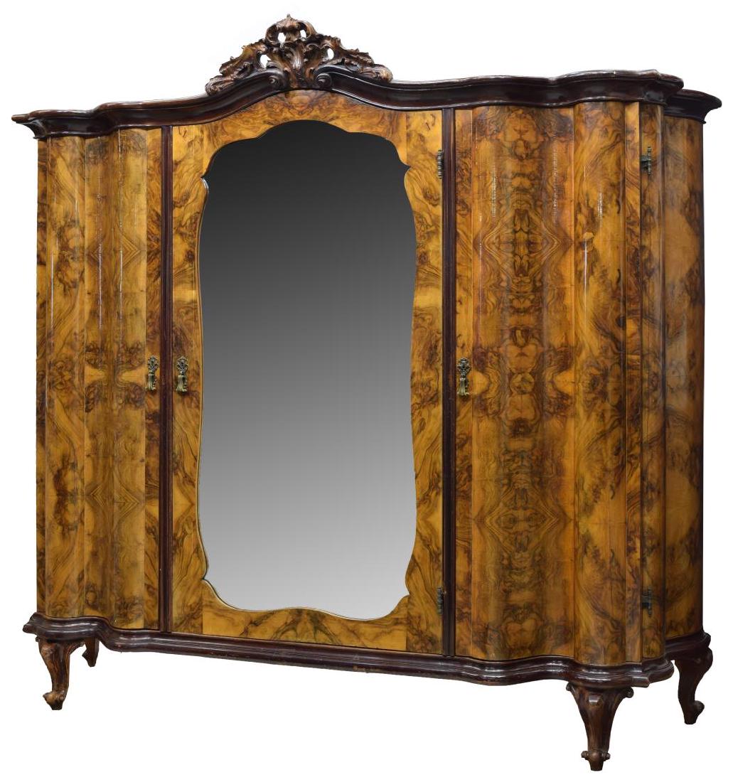 VENETIAN BURL WALNUT TRIPLE ARMOIRE: Venetian burl walnut triple armoire, the pierced and carved foliate scroll crest surmounting a corniced top and a serpentine face body, fitted with three cabinets, the middle door having a beveled mir