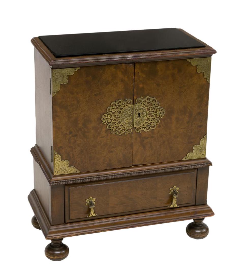 ENGLISH BURLWOOD METAL-LINED TABACCO CABINET: English burlwood tobacco cabinet, having a black glass top and brass accents, the two-door cabinet opening to a metal-lined interior with a pierced shelf, over a single drawer and rising on bun feet, 