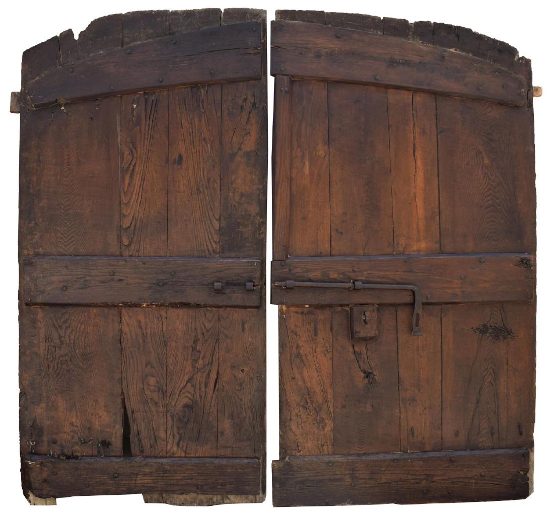 ARCHITECTURAL MONASTERY BARN DOUBLE DOORS: Italian architectural monastery barn doors, 17th c., having slightly arched top, double doors, with horizontal board bracing, and iron hardware, wear, evidence of outdoor use, approx 83.5"h, 88.5"w St