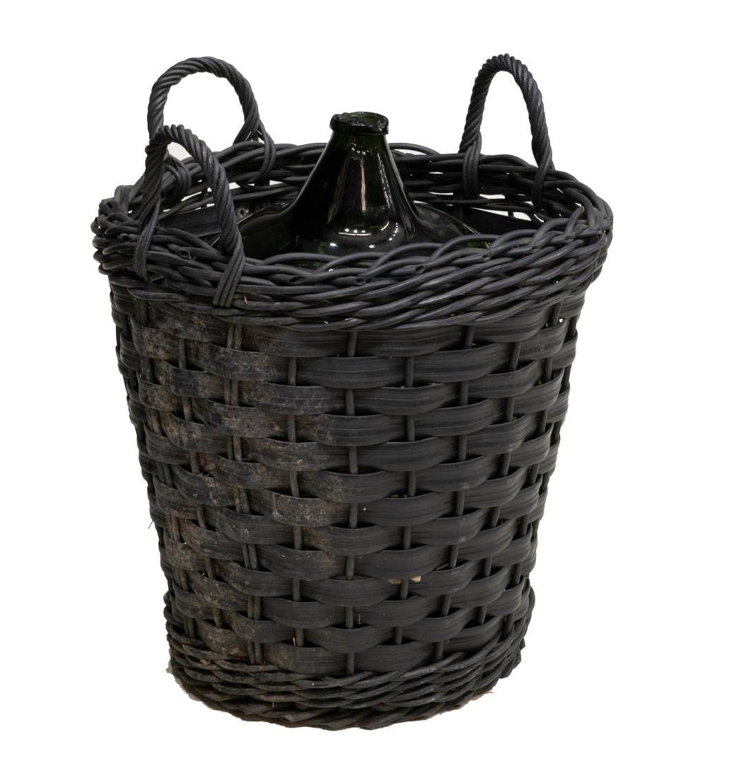 FRENCH GREEN GLASS BORDEAUX WINE CELLAR BOTTLE: French green glass bordeaux wine cellar bottle, 19th/20thc., in a later rubber-like 'wicker' basket with three handles, bottle: 24"h, basket: 19.5"diam Start Price: $100.00