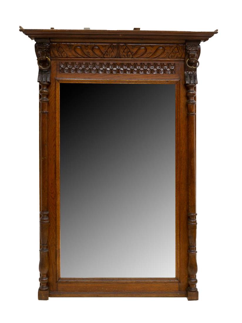 FRENCH RENAISSANCE REVIVAL CARVED OAK WALL MIRROR: French Renaissance Revival oak hanging wall mirror, molding on cornice, lion masks with iron rings in mouth surmount, carved frame surrounds beveled mirror plate, flanked by ball and ring posts, 47"h,