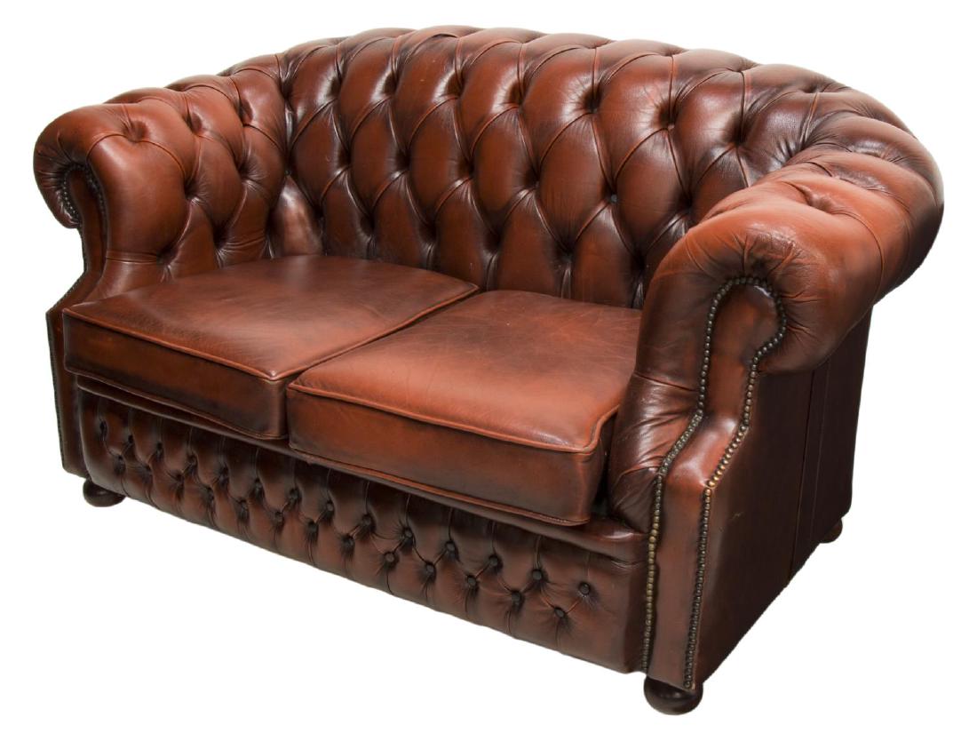 ENGLISH OX BLOOD LEATHER CHESTERFIELD 2-SEAT SOFA: English chesterfield sofa, manufactured by Winchester Furniture, in ox blood leather, having button back and arms, with nail head accents, two removable seat cushions, rising on bun feet, approx 33.5"